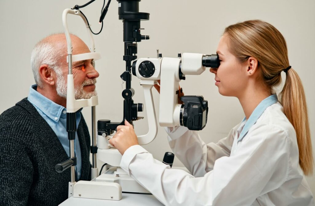 An optometrist carefully examines a patient's eyes in a slit lamp to determine if their diabetes is causing eye problems.